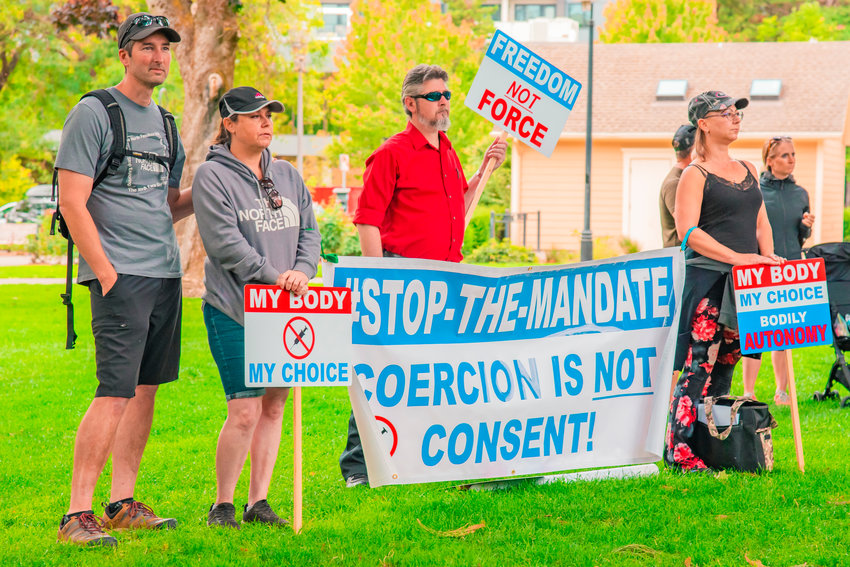 Demonstrators hold signs during a freedom rally in opposition to vaccine mandates at Esther Short Park in Vancouver on Friday.