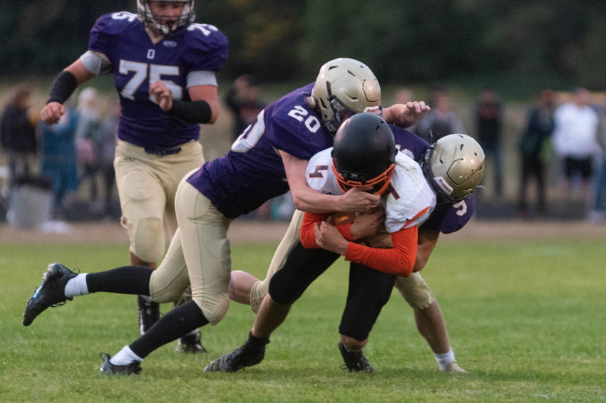 FILE PHOTO -- Napavine quarterback Ashton Demarest is brought down by two Onalaska defenders in the Tigers win over the Loggers Sept. 10.