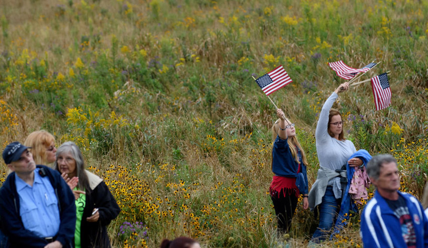 Visitors wave flags while listening to President Donald Trump deliver a speech at the Flight 93 National Memorial commemorating the 17th Anniversary of the crash of Flight 93 and the September 11th terrorist attacks on September 11, 2018 in Shanksville, Pennsylvania. (Jeff Swensen/Getty Images/TNS)