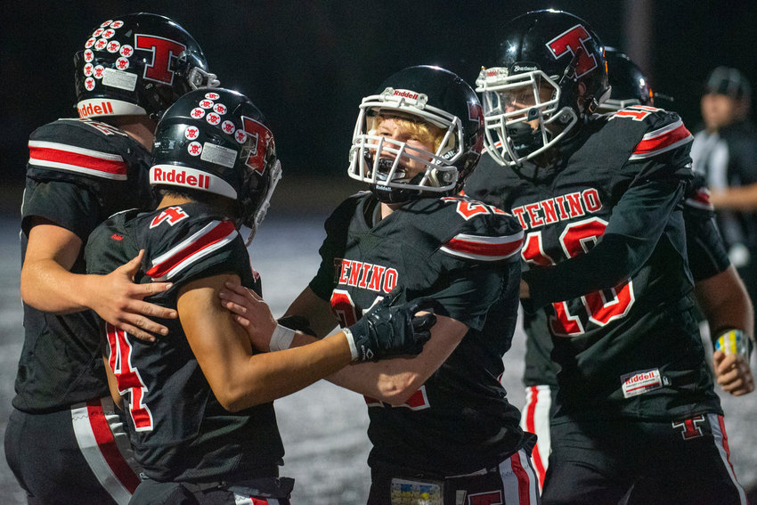Tenino's Lucas Watterson (4) is congratulated by teammates Toby Suess (21) and Tremaine Burras (10) after scoring a touchdown against North Beach.