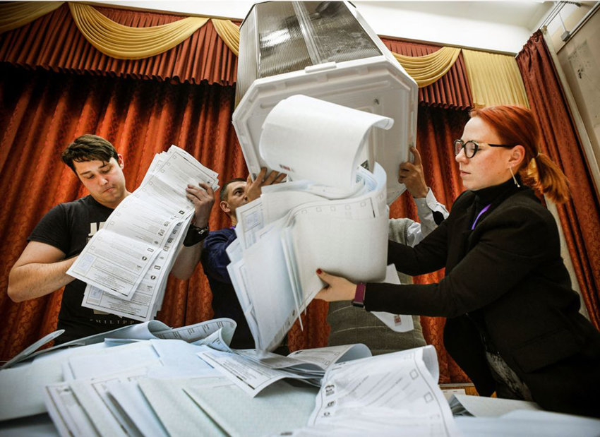 Members of a local electoral commission empty a ballot box at a polling station after the last day of the three-day parliamentary election, in Moscow, on September 19, 2021. (Alexander Nemenov/AFP via Getty Images/TNS)