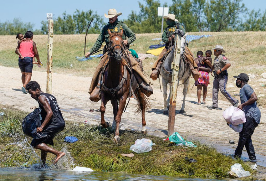 United States Border Patrol agents on horseback try to stop Haitian migrants from entering an encampment on the banks of the Rio Grande near the Acuna Del Rio International Bridge in Del Rio, Texas on September 19, 2021. (Paul Ratje/AFP via Getty Images/TNS)