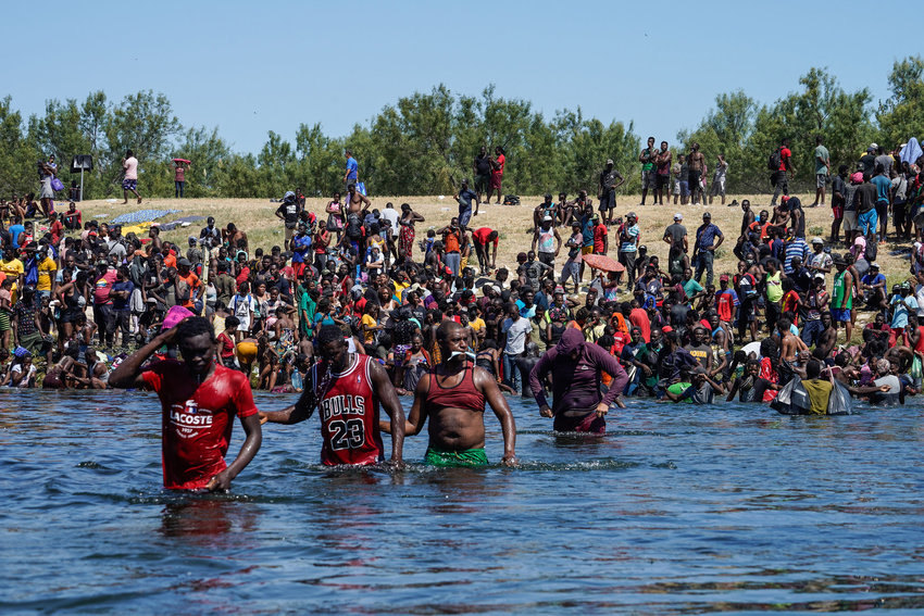 Haitian migrants cross the Rio Grande river to get food and water in Mexico, after another crossing point was closed near the Acuna Del Rio International Bridge in Del Rio, Texas on Sept. 19, 2021. (Paul Ratje/AFP/Getty Images/TNS)