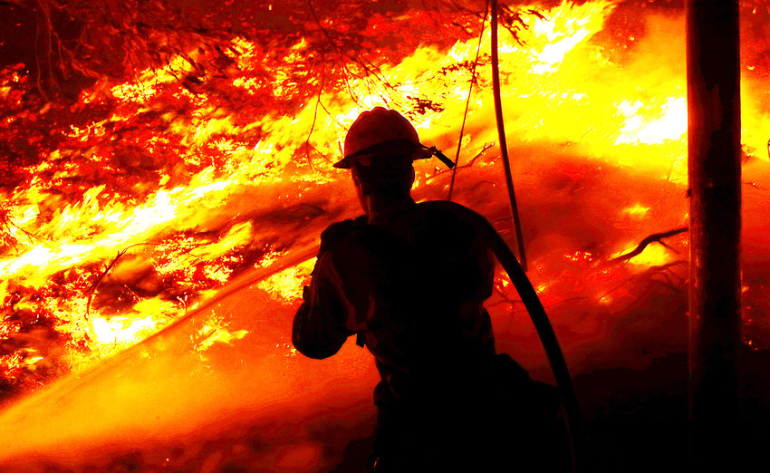 A firefighter battles the Alisal fire along the 101 Freeway near Goleta on Tuesday, Oct. 12, 2021. (Luis Sinco/Los Angeles Times/TNS)