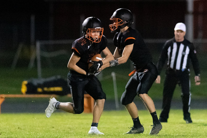 FILE PHOTO -- Napavine quarterback Ashton Demarest hands the ball off to Peyton League on a fly sweep against Forks Oct. 22.