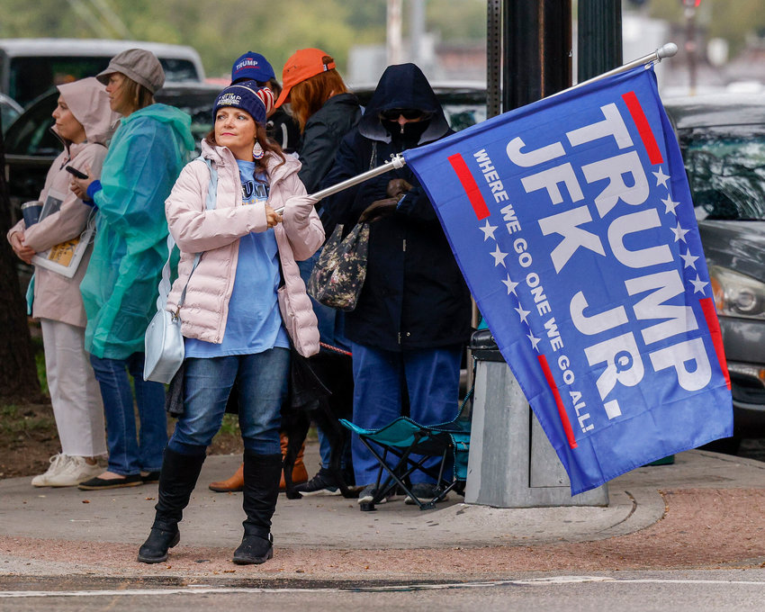 A woman waves a Donald Trump and John F. Kennedy Jr. flag along Elm Street at Dealey Plaza in downtown Dallas on Tuesday, Nov. 2, 2021. The group believes John F. Kennedy Jr., who died in plane crash in 1999, will return and reinstate Donald Trump as president. (Elias Valverde II/The Dallas Morning News/TNS)