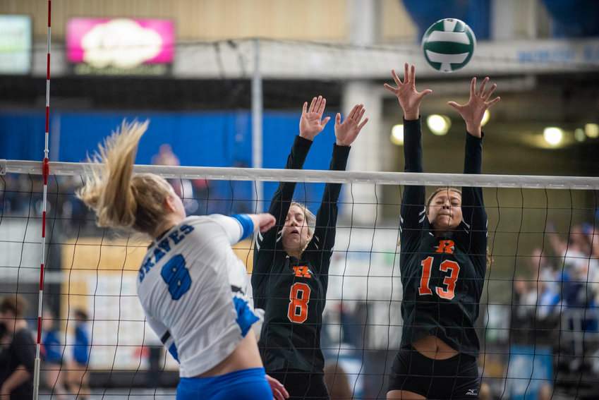 Rainier&rsquo;s Olivia Earsley (8) and Janess Blackburn (13) attempt to block a shot by La Conner&rsquo;s Ellie Marble (8) during the first round of the 2B state volleyball tournament Thursday in Yakima.