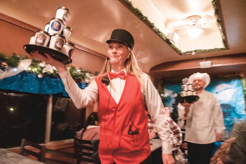 Tracy Meyer and Austin Jones carry stacks of hot cocoa during dress rehearsals for The Polar Express train rides with family only onboard in 2021.