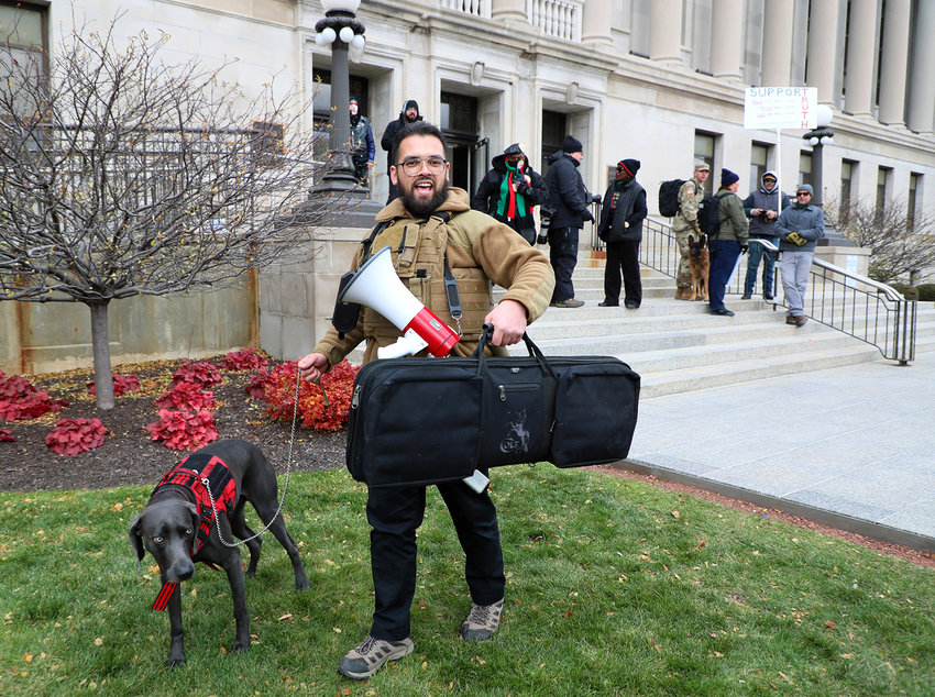 Jesse Kline arrives with his dog and what appears to be a rifle case outside the Kenosha County Courthouse on the third day of jury deliberations in the Kyle Rittenhouse case on Nov. 18, 2021, in Kenosha.Throughout the trial, gun rights advocates congregated outside the building. (Stacey Wescott/Chicago Tribune/TNS)