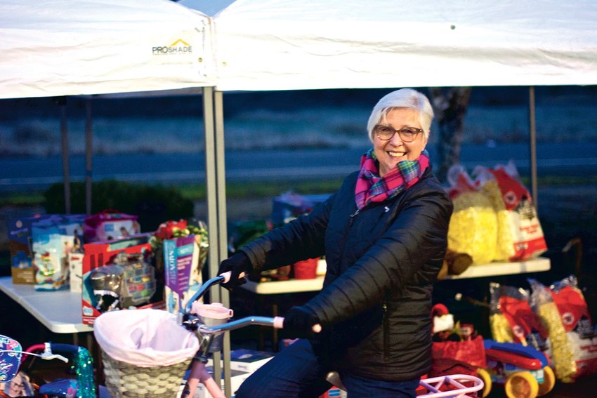 Julie Shaffley, of the Centralia-Chehalis Chamber of Commerce shows off a bike that was given away as a prize for the chamber&rsquo;s &ldquo;Choose Local Black Friday&rdquo; event Lewis County Mall Wednesday night.
