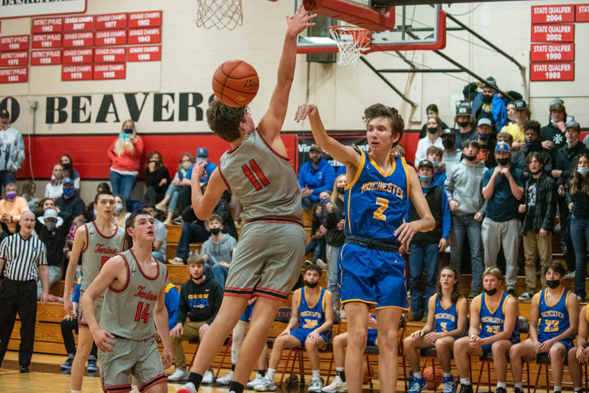 Rochester's Tyler Klatush (2) dishes off a pass under the hoops against Tenino on Nov. 29.