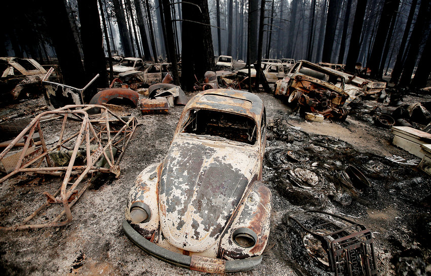 Scorched trees and burned automobiles lay scattered in Grizzly Flats on Aug. 18, 2021, after the Caldor fire burned through Northern California. (Luis Sinco/Los Angeles Times/TNS)