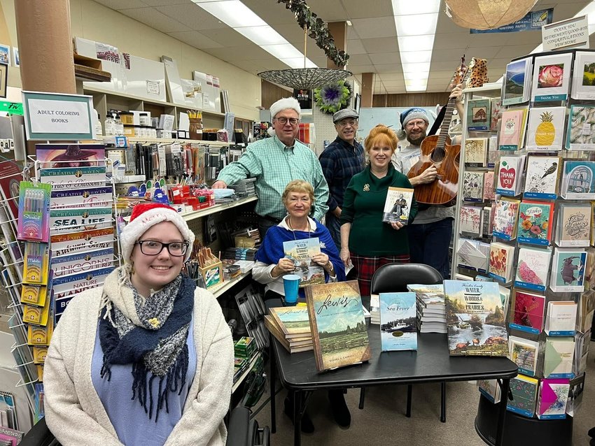 From left, Moriah Pitts, Bill Lindstrom, Sandy Crowell, Brad Meagher, Kerry MacGregor Serl, and Brian Mittge pose for a photo at Book &rsquo;N&rsquo; Brush during their Friends and Family Christmas Party Saturday in Chehalis.