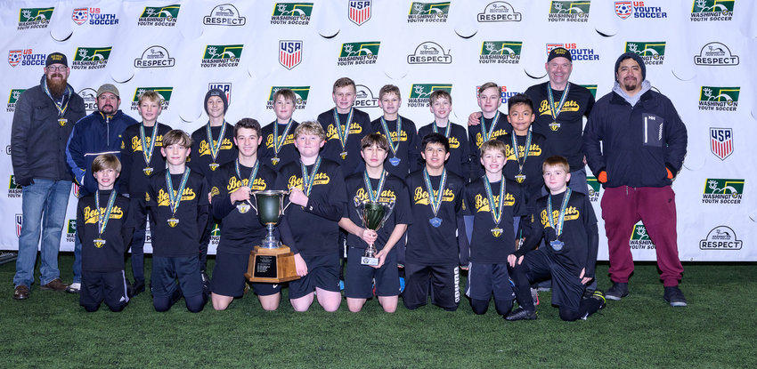 The Bad News Bearcats 14U boys soccer team poses with their state championship trophy at Starfire Stadium in Tukwila on Dec. 11.