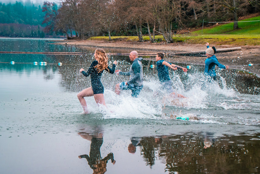 From left to right, former Miss Lewis County Angela March, Peter Abbarno, Franklin Taylor  and Holly Abbarno run into Mayfield Lake during a Polar Plunge event to raise money for the Lewis County Special Olympics and Special Olympics of Washington in January 2021 near Mossyrock.