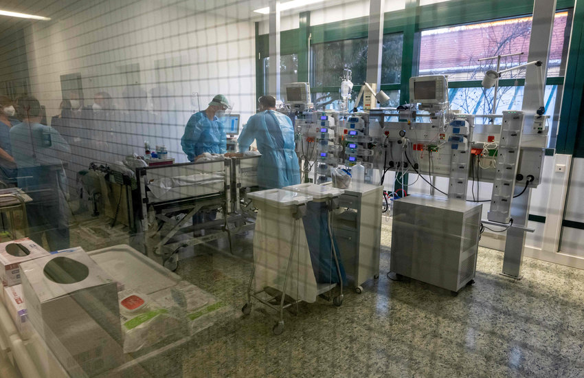 Medical staff tend to a patient infected with the coronavirus (COVID-19) at the intensive care unit (ICU) of the clinic in Munich-Schwabing, southern Germany on Wednesday, Dec. 22, 2021. (Peter Kneffel/Pool/AFP/Getty Images/TNS)