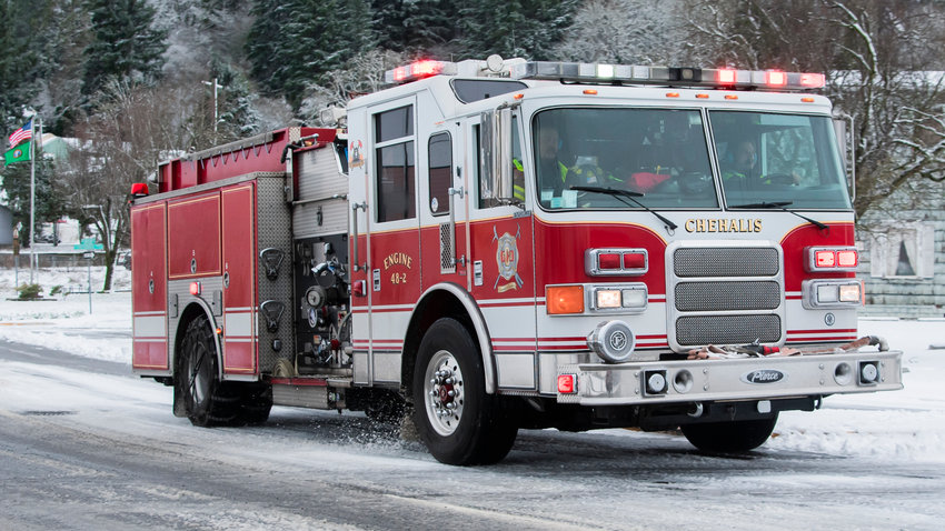A fire engine drives through downtown Chehalis with lights illuminated last December.