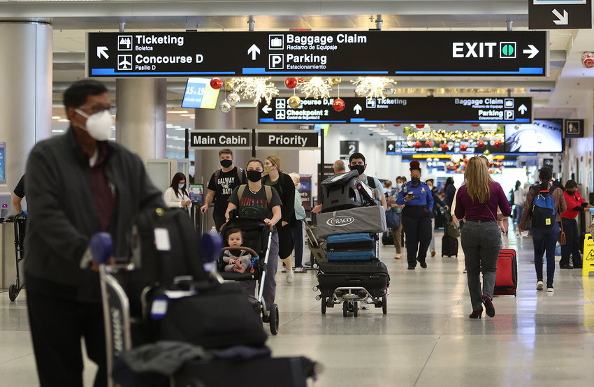 Travelers make their way through Miami International Airport on Dec. 28, 2021, in Miami, Florida. (Joe Raedle/Getty Images/TNS)