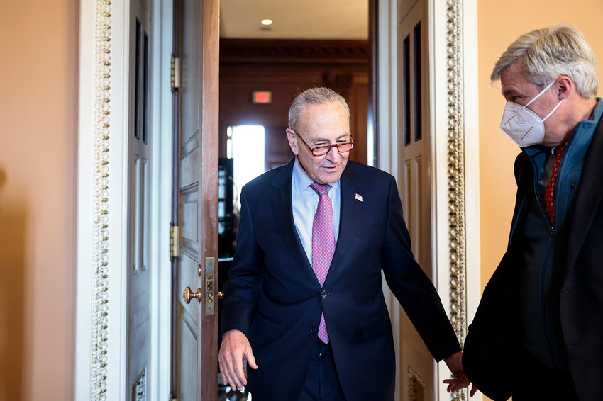 Senate Majority Leader Chuck Schumer, left, and Sen. Sheldon Whitehouse, D-R.I., leave a caucus meeting with Senate Democrats at the U.S. Capitol Building on Dec. 17, 2021, in Washington, D.C. (Anna Moneymaker/Getty Images/TNS)