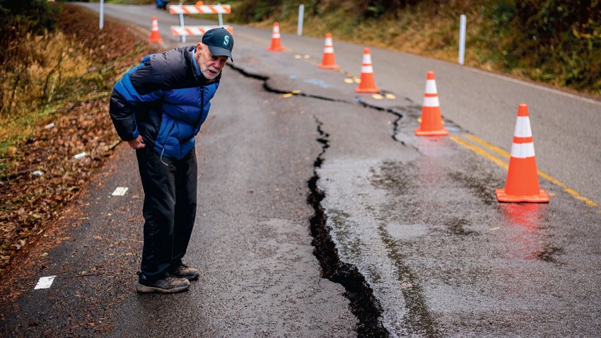 FILE PHOTO &mdash;&nbsp;Erik Dahl looks down at a crack which continues to form in the 2100 block of Little Hanaford Road in Centralia in January.