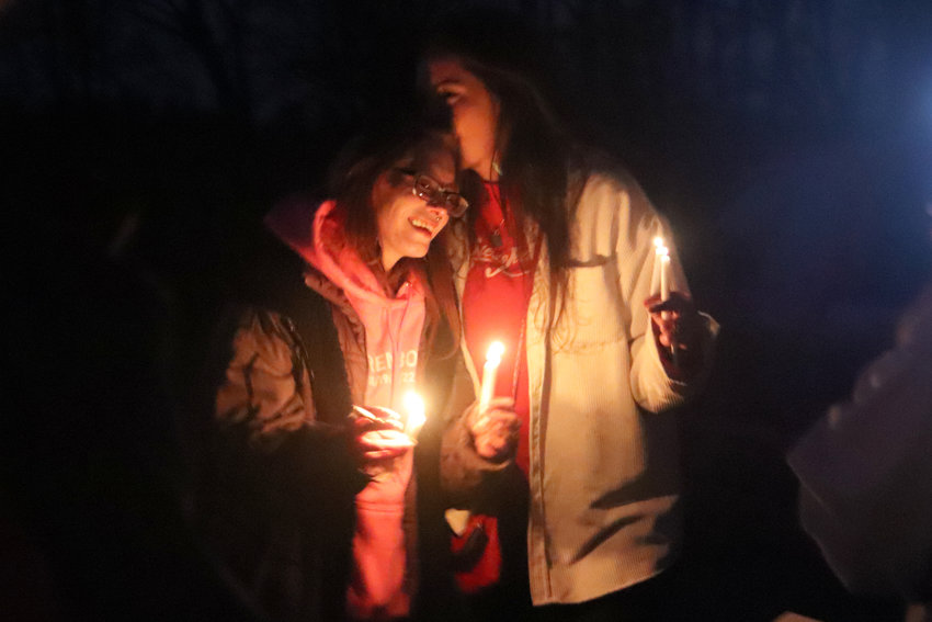 Sisters Karlee and Taylor Bodine share a tender moment at a vigil held on the 15th anniversary of the day their mother&rsquo;s body was found on the side of Little Rock Road Southwest near Rochester.