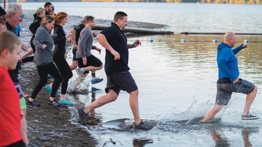 State Rep. Peter Abbarno leads a Polar Plunge into Mayfield Lake followed by Centralia Police Chief Stacy Denham during an event that benefits Lewis County Special Olympics athletes Saturday morning near Mossyrock.