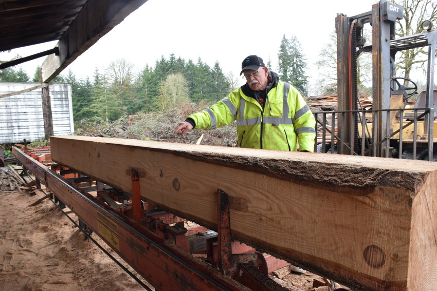 Dollar&rsquo;s Corner Sawmill operator Pat Lydon examines a log at the sawmill on Feb. 4.