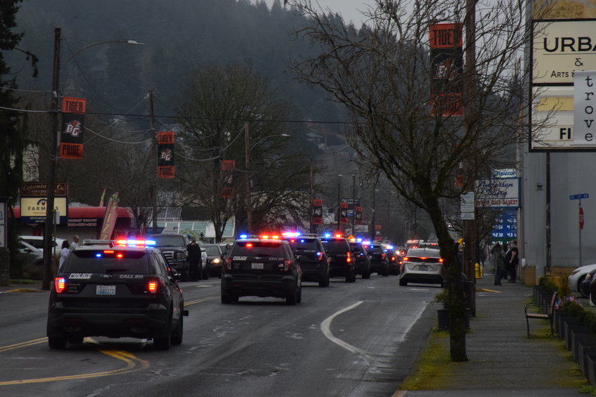 Law enforcement vehicles drive on Main Street in Battle Ground toward Layne&rsquo;s Funeral Home in a procession for Vancouver Police Department Officer Donald Sahota on Feb. 3.