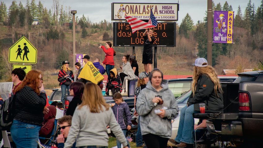 Onalaska students stand on their vehicles waving signs and flags during a student lead protest along Carlisle Avenue Wednesday morning.