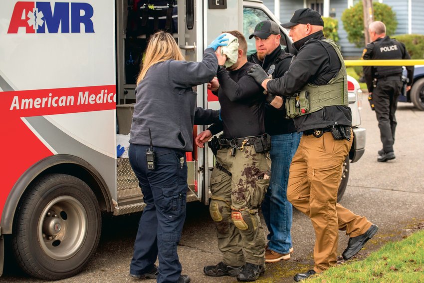 First responders aid Centralia Police Officer Stephen Summers, a K9 handler, as he walks into an ambulance after being stabbed while attempting to contact a suspect with a weapon last Friday.