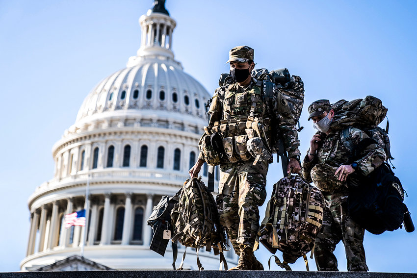 Members of the National Guard carry supplies near the U.S. Capitol on Jan. 14, 2021. Capitol Police and D.C. government officials have requested the National Guard&rsquo;s assistance with a truck convoy headed to Washington, D.C. (Kent Nishimura/Los Angeles Times/TNS)