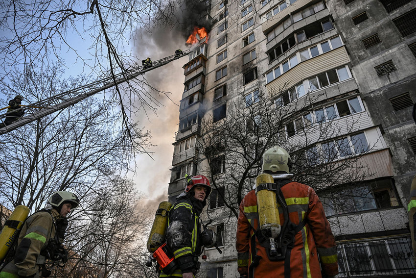 Firefighters extinguish a fire in an apartment building in Kyiv on March 15, 2022, after strikes on residential areas killed at least two people, Ukraine emergency services said as Russian troops intensified their attacks on the Ukrainian capital. (Aris Messinis/AFP via Getty Images/TNS)