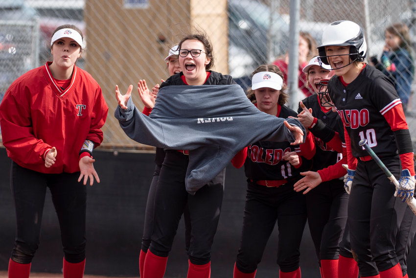 Toledo players cheer and wait for Abbie Marcil at home plater after Marcil's home run against Tenino on the road March 16.