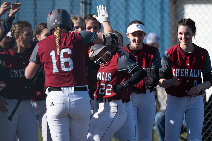 W.F. West's Avalon Myers (22) is swarmed by teammates at home plate after a home run against Rochester March 22.