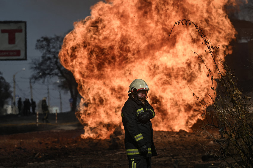 A Ukrainian firefighter stands next to flames rising from a fire following artillery fire on the 30th day on the invasion of the Ukraine by Russian forces in the northeastern city of Kharkiv on March 25, 2022. (Aris Messinis/AFP via Getty Images/TNS)