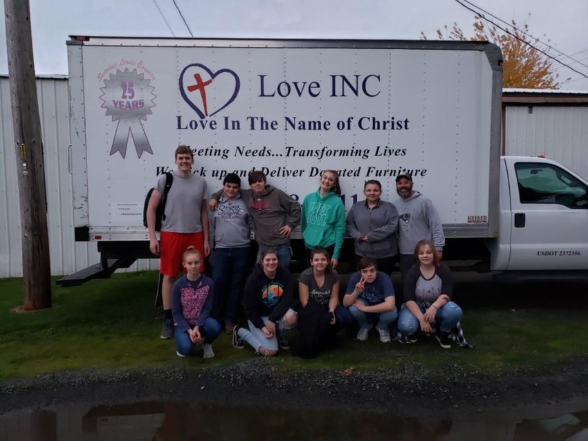 Volunteers pose in front of a Love INC truck in this photograph provided by the nonprofit.