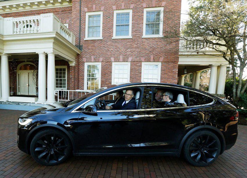 Washington Gov. Jay Inslee drives away from the Governor's Mansion in a Tesla Model X 75D semi-autonomous electric vehicle, Monday, Jan. 23, 2017, at the Capitol in Olympia, Wash. Inslee was test-driving the car to highlight the state's role in the testing and development of autonomous vehicle technology and to tout the environmental and safety benefits of the vehicles. (AP Photo/Ted S. Warren)