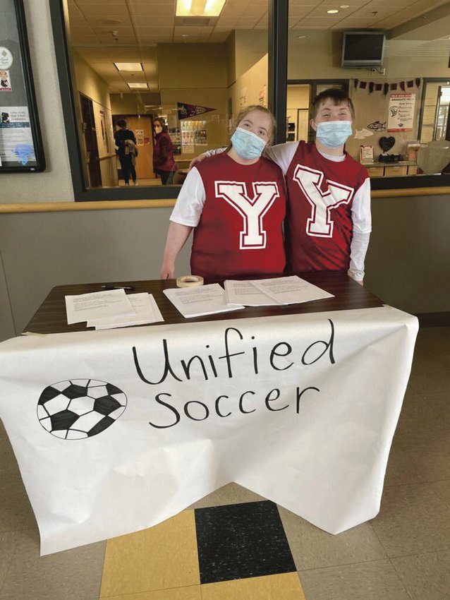 Unified Soccer teammates Destinee Jones (left) and Mose Knight (right) pose for a picture at the recruitment table during lunch.