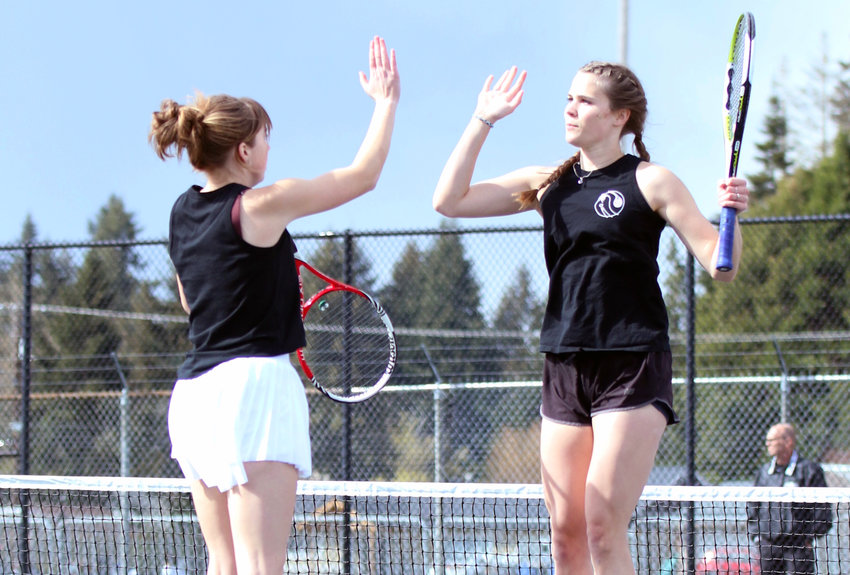 Centralia's No. 1 doubles duo Liza Hopkins, left, and Maddie Corwin leap for a high-five during a home match against Stevenson on Friday, April 15.