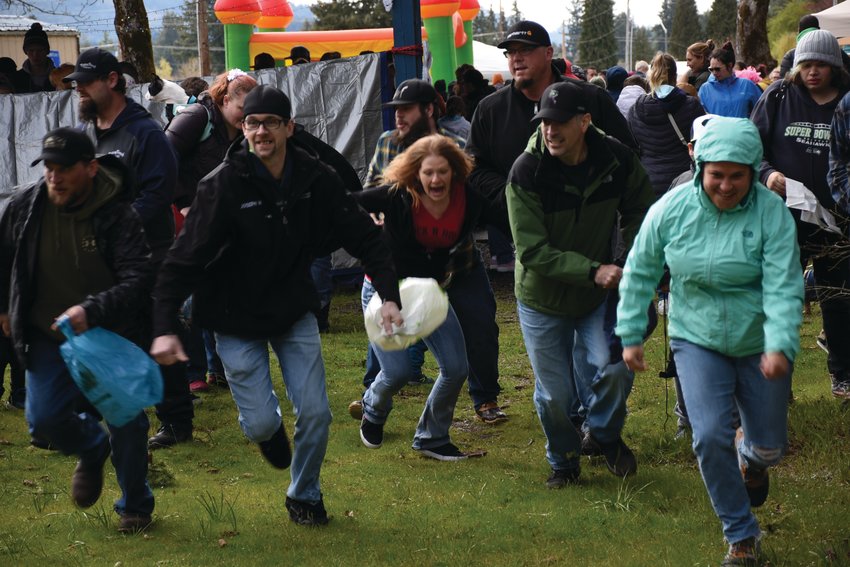 Adults scramble for eggs filled with candy and prizes in an Easter egg hunt just for them on Saturday, April 16 at Wilkowski Park in Rainier.