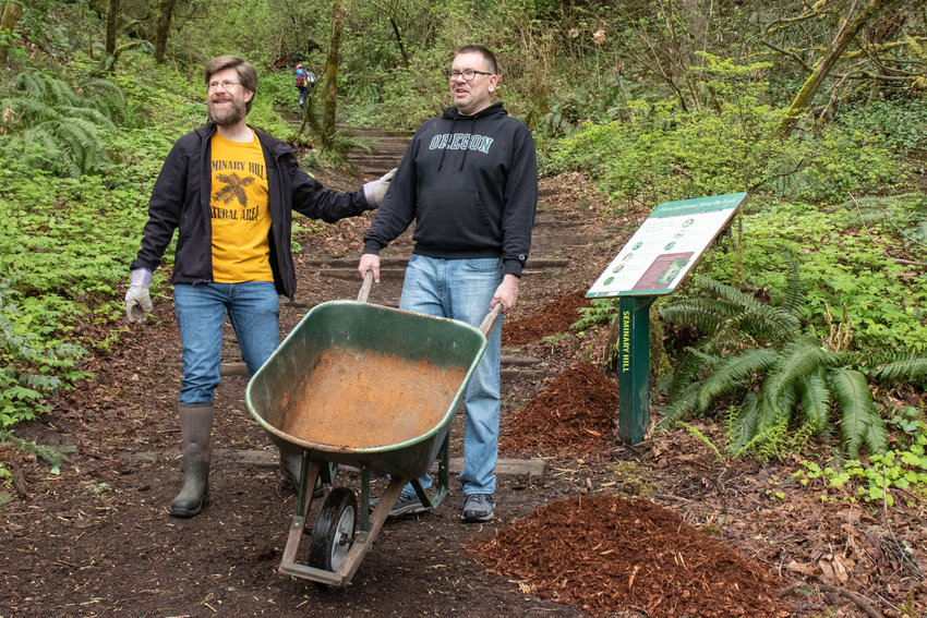 Brian Mittge and Chris brewer unload bark chips on a trail during the Friends of the Seminary Hill Natural Area Earth Day Work Party in Centralia.