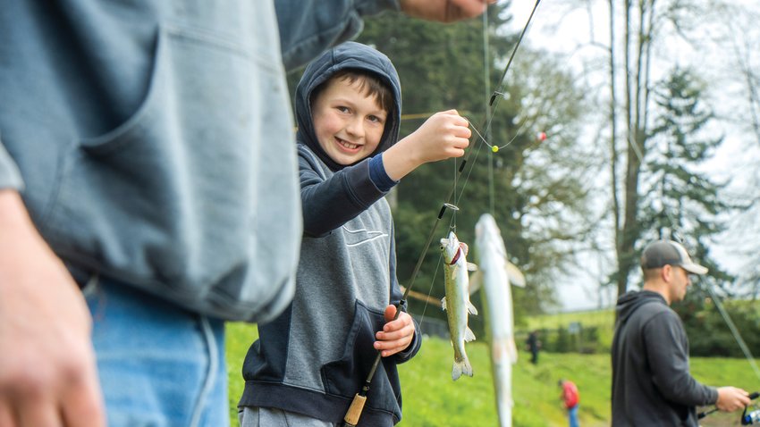 Tristan Johnson, 10, smiles as he holds up fish alongside Dana Johnson during the Fort Borst Park Fishing Derby Saturday. Note that these photographs were captured just before the official start of the event and more young anglers showed up throughout the day.