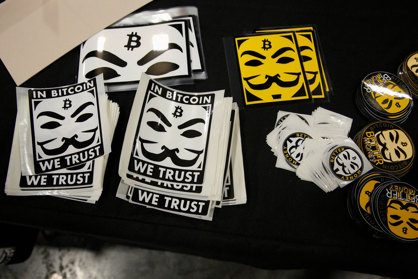 Stickers depicting Guy Fawkes masks and the bitcoin logo are seen at a stand in the exhibition hall during the Bitcoin 2022 Conference at Miami Beach Convention Center on April 8, 2022, in Miami. (Marco Bello/Getty Images/TNS)