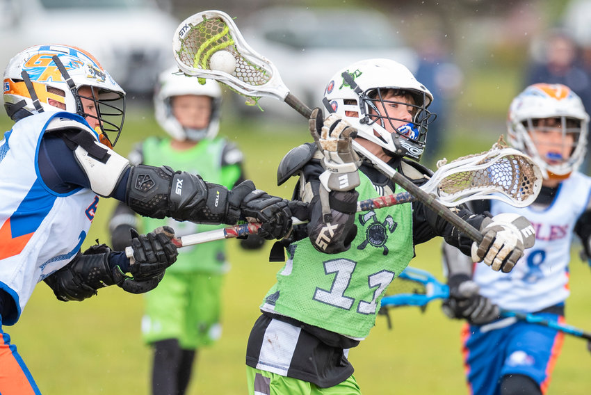 Twin Cities Lacrosse's Easton Buck (11) tries to evade a Graham-Kapowsin defender during a home game at Olympic Academy in Chehalis on April 30.