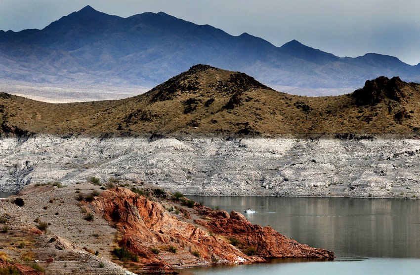 A boat navigates Lake Mead, where a white &quot;bathtub ring&quot; along the shore shows how far below capacity the nation's largest reservoir currently is, June 11, 2021. A barrel containing human remains has been discovered in Nevada's Lake Mead. (Luis Sinco/Los Angeles Times/TNS)