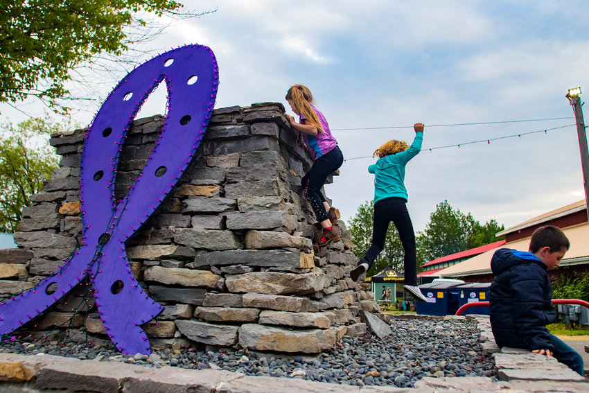 FILE PHOTO &mdash;&nbsp;Children climb around a purple ribbon decoration during the Relay For Life at the Southwest Washington Fairgrounds.