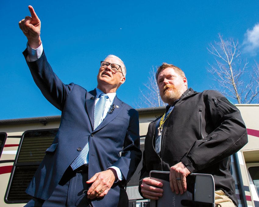 FILE PHOTO &mdash; Gov. Jay Inslee points to the isolation area of what at the time was considered a potential COVID-19 quarantine site during a tour with Washington State Department of Health Commander Nathan Weed at Maple Lane in March 2020.