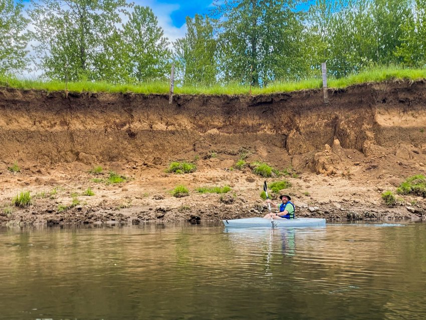 Brian Mittge paddles near an eroded bank of the Chehalis River Monday afternoon.