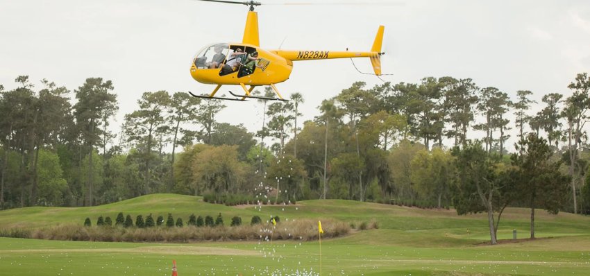 Above, a helicopter drops golf balls that contain raffle numbers at the Tri-Mountain Golf Course in Ridgefield on May 21.