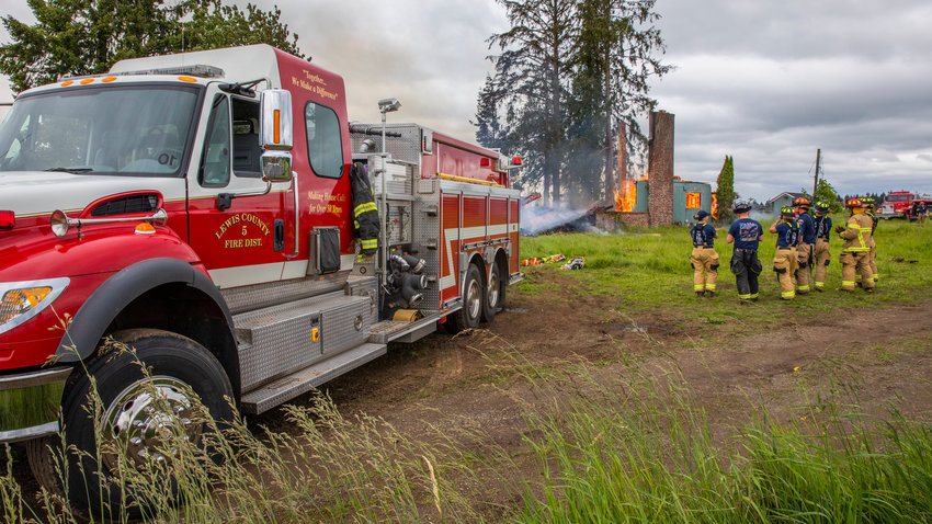 A Lewis County Fire District 5 engine is seen near a structure used in a fire training exercise Saturday in Winlock.